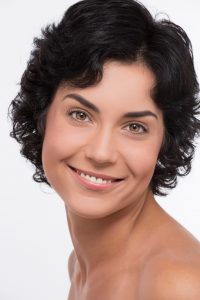 Front portrait of the woman with beauty face isolated on white background. Middle-aged black-haired woman smiling for the camera.